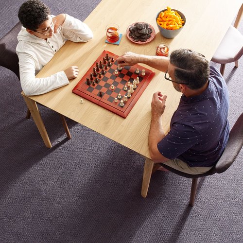 Father playing chess with his son in a room with gray carpet floor from Eastern Floor Covering in Virginia area